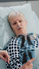 Portrait of young woman lying on bed at home