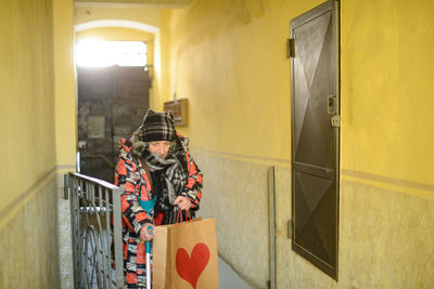 Senior east european disabled woman entering a building 