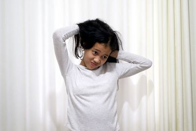 Portrait of boy standing against white wall