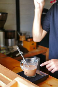 Midsection of woman holding ice cream in cafe