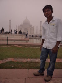 Full length of man standing outside temple against sky