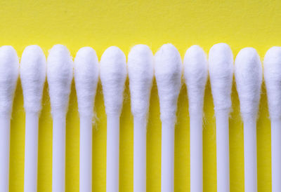 Close-up of cotton swabs arranged on blue table