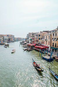 Boats moored in canal against buildings in city