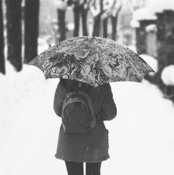 Rear view of man holding snow