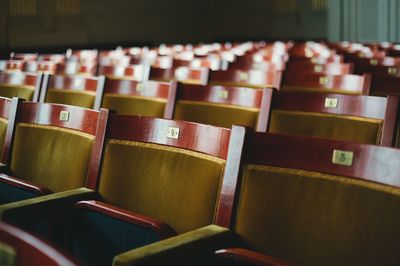 Empty wooden chairs with numbers in auditorium