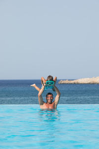Man in sea against sky