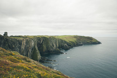 Scenic view of sea and cliff against sky