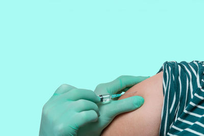 Close-up of human hand against blue background