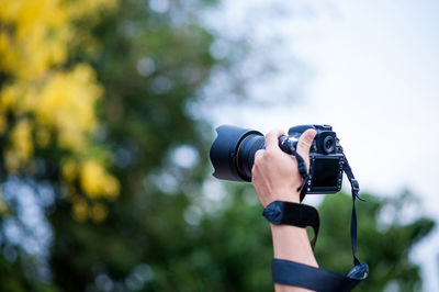 Cropped hand holding camera