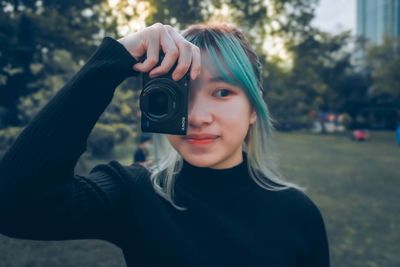 Portrait of young woman photographing