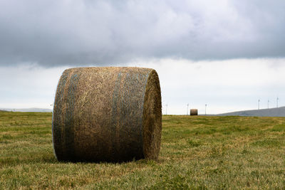 Hay bales on field against sky