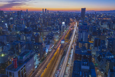 High angle view of illuminated highway amidst buildings in city against sky