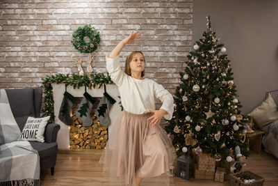 Girl standing by christmas tree