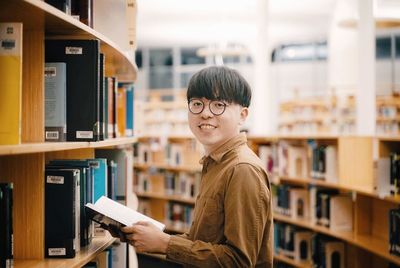 Portrait of young man reading book