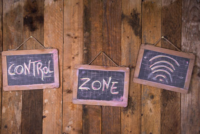 Close-up of information sign hanging on wooden wall