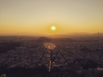 Aerial view of illuminated cityscape against sky during sunset