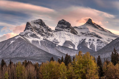 Scenic view of snowcapped mountains against cloudy sky during sunset