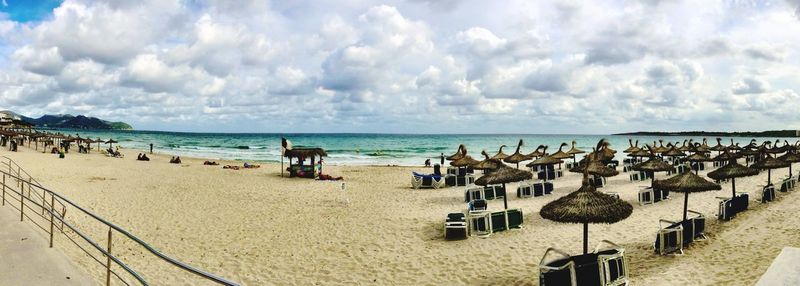 Scenic view of beach against cloudy sky