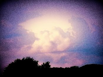 Silhouette of trees against dramatic sky