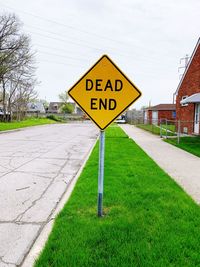 Information sign on road against sky