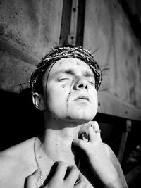 Close-up of shirtless man wearing thorns crown