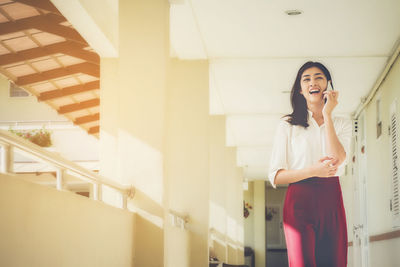 Young woman talking on mobile phone in corridor