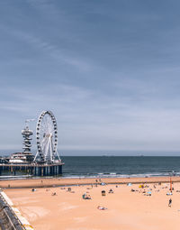 Ferris wheel at beach against sky