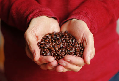 Close-up of hand holding coffee beans