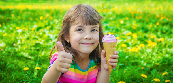 Portrait of smiling young woman sitting on field