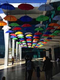 People walking on multi colored umbrellas