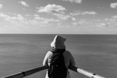 Rear view of woman looking at sea against sky