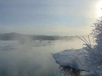 Scenic view of lake against sky during winter