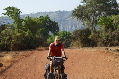 Portrait of man riding motorcycle on dirt road