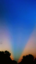 Low angle view of silhouette trees against sky at sunset