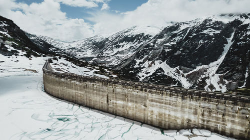The gelmersee dam and its icy lake in the swiss alps in spring