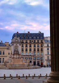 Facade of historical building against cloudy sky