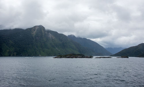 Scenic view of sea and mountains against sky