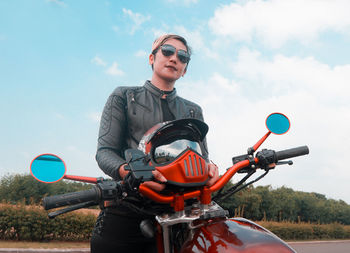 Low angle view of man riding motorcycle against sky