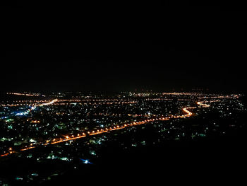 High angle view of illuminated buildings against sky at night