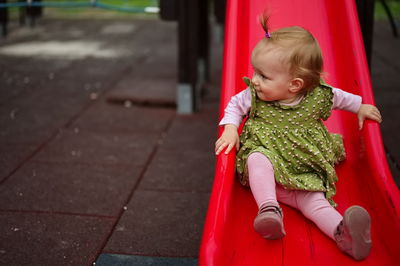 Little baby girl playing on toboggan