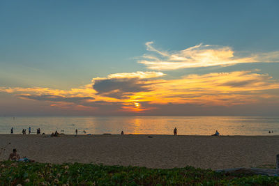 Group of people on beach at sunset