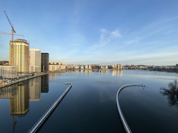 Reflection of buildings in river against sky