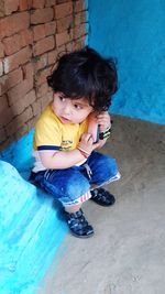 High angle view of cute boy sitting on floor