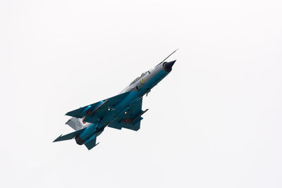 Low angle view of bird flying against clear blue sky