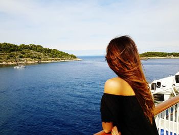 Rear view of woman looking at sea against sky