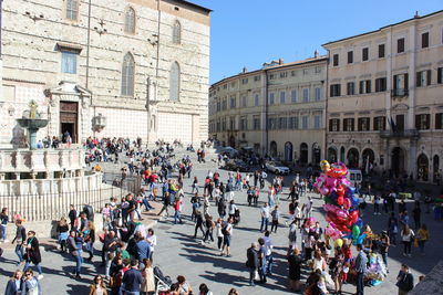 People on street against buildings in city