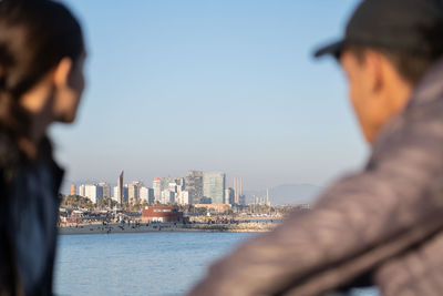 Side view of man looking at sea against sky