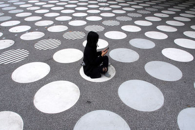 High angle view of woman sitting on tiled floor