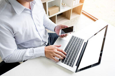 Midsection of man using mobile phone