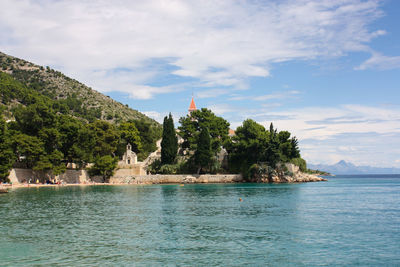 Scenic view of sea by building against sky